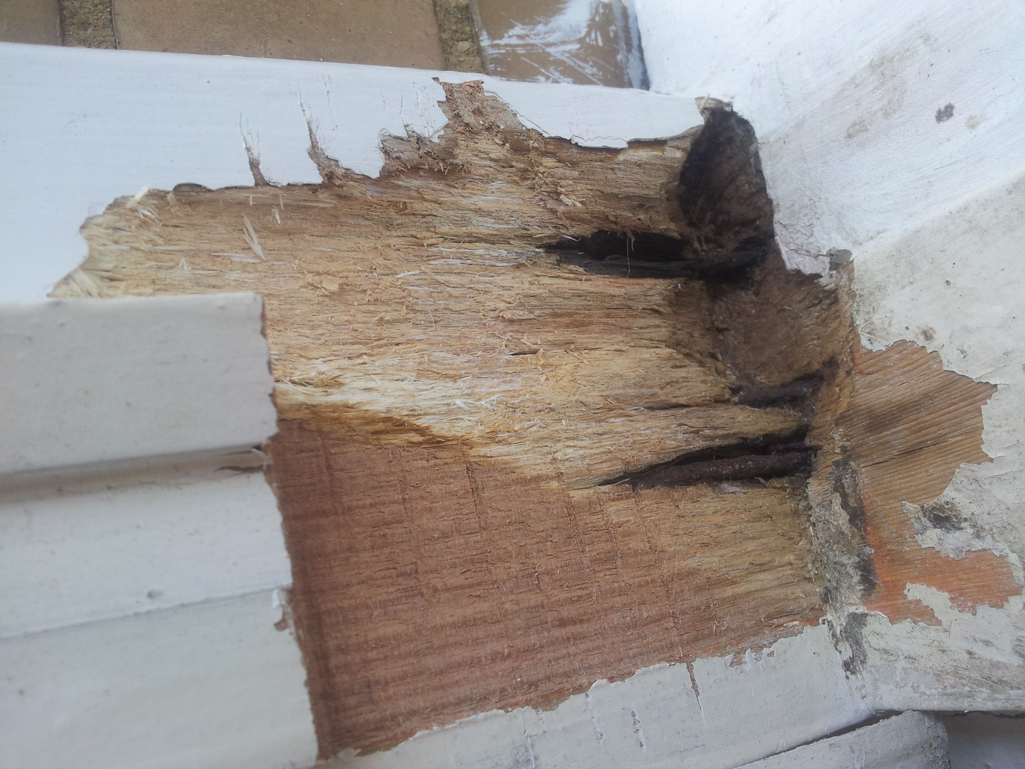 Houten kozijn met verwijderd rot hout, vóór het herstel